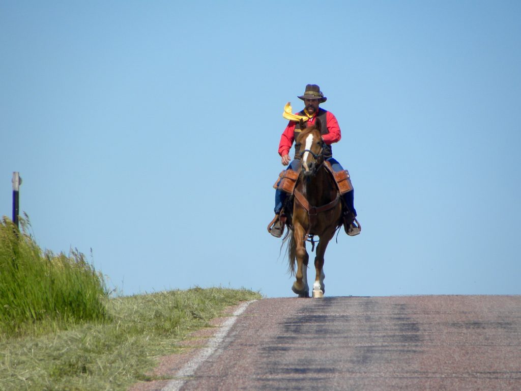 Wyoming Rider riding on the trail on a sunny day, bright blue sky. 